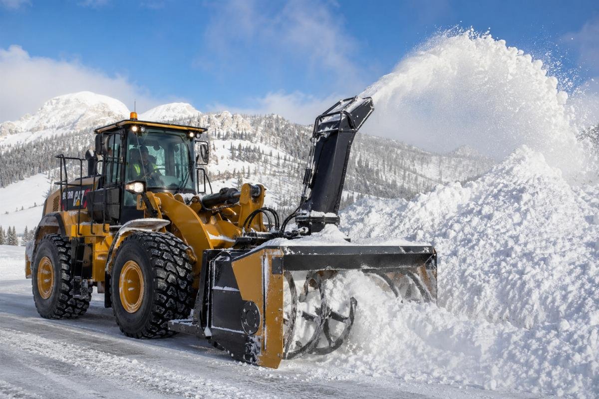 A wheel loader with a snow thrower attachment moving deep snow into a large pile